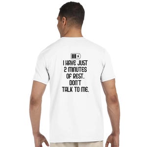Könnte beinhalten: Ein weißes kurzärmeliges T-Shirt mit einer schwarzen Grafik auf der Rückseite. Die Grafik zeigt ein Batteriesymbol und den Text: I HAVE JUST 2 MINUTES OF REST. DON'T TALK TO ME. Das T-Shirt hat einen Rundhalsausschnitt und eine Standardpassform.