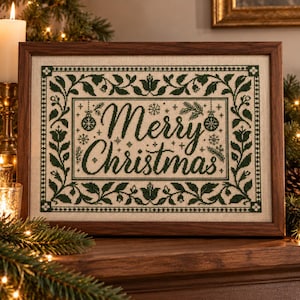 May include: A framed cross-stitch embroidery featuring the text Merry Christmas in dark green thread on a light beige fabric. The design includes a decorative border of green leaves and flowers, with small snowflake and ornament motifs.