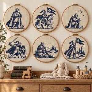 Può includere: Sei telai da ricamo circolari con disegni a punto croce blu scuro di cavalieri medievali su tessuto beige chiaro. Le scene raffigurano cavalieri in piedi, a cavallo, in ginocchio, con spada e scudo, a riposo e che reggono una bandiera.