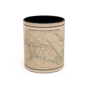 May include: A cylindrical mug with a black interior and rim, featuring a tan-colored exterior wrap printed with a historical map titled Military Map of South-Eastern Virginia. The map displays intricate black lines representing geographical details.