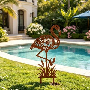 Könnte beinhalten: Ein rostfarbener Gartenstecker aus Metall in Form eines Flamingos, der auf einem Bein steht. Die Flamingo-Silhouette weist filigrane Ausschnitte auf, darunter eine markante Hibiskusblüte am Körper und stilisierte Schilfkolben am Fuß.