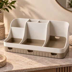 Op de afbeelding: Een tweekleurige bureau-organizer met een wit bovengedeelte met meerdere vakken en een beige onderkant. De basis heeft drie kleine rechthoekige uitsparingen aan de voorzijde en de bodem van de organizer is beige van kleur.