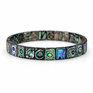 Puede incluir: Una pulsera elástica compuesta por piezas rectangulares de concha de abulón. Cada pieza presenta un patrón iridiscente único con tonos arremolinados de azul profundo, verde vibrante y morado sobre un fondo oscuro y pulido.