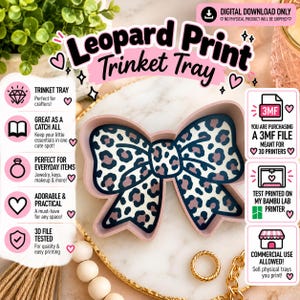 May include: A digital download 3MF file for a 3D printed bow-shaped trinket tray featuring a leopard print pattern. The tray has light pink walls and a white base with black and brown spots. Text includes Leopard Print Trinket Tray.