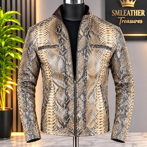 May include: A zip-up jacket featuring a tan and black snakeskin pattern, a stand-up collar, and two horizontal zippered chest pockets. The garment is displayed on a mannequin, showcasing a textured finish and a dark brown inner lining.