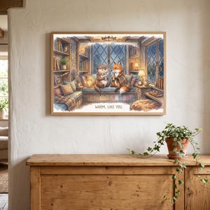 Peut inclure: Une impression d'art murale rectangulaire dans un cadre en bois clair représentant une illustration à l'aquarelle d'une loutre et d'un renard assis sur un banc de fenêtre dans une bibliothèque, tenant des tasses, avec le texte WARM. LIKE YOU.