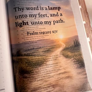 May include: An open Bible page featuring a printed landscape illustration of a winding path at sunset. The text reads: Thy word is a lamp unto my feet, and a light unto my path. Psalm 119:105 KJV. The page includes indexed tabs on the right edge.