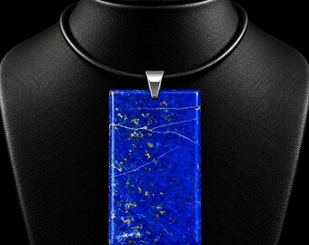 Könnte beinhalten: Ein rechteckiger Lapis-Lazuli-Anhänger aus einem tiefblauen Stein mit natürlichen goldfarbenen Pyrit-Einschlüssen und feinen weißen Calcit-Adern. Der Anhänger hängt an einer silberfarbenen Metallöse an einer glatten schwarzen Kordelkette.