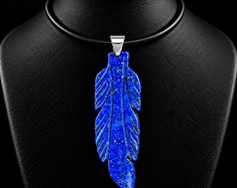 Könnte beinhalten: Ein tiefblauer Lapis-Lazuli-Anhänger in Federform mit sichtbaren goldfarbenen Pyrit-Einschlüssen. Der Anhänger ist an einer silberfarbenen Metallöse befestigt und hängt an einer glatten schwarzen Kordelkette.
