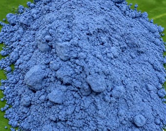 Könnte beinhalten: Ein Haufen aus feinem, leuchtend blauem Pigmentpulver mit einer körnigen, klumpigen Textur. Das Pulver ist kegelförmig aufgeschüttet und weist eine gleichmäßige, tief kornblumenblaue Farbe in der gesamten losen Masse auf.