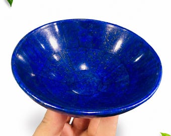 Könnte beinhalten: Eine kreisförmige Schale aus tiefblauem Lapislazuli-Stein mit polierter, glänzender Oberfläche und sichtbaren natürlichen goldenen Pyrit-Einschlüssen, die eine segmentierte, mosaikartige Struktur aufweist.