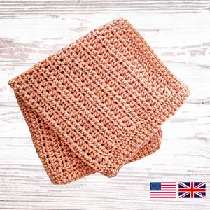 May include: A folded peach-colored crocheted dishcloth or kitchen towel. The cloth is made with a simple stitch pattern and has a soft, textured surface.