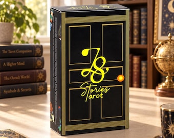Puede incluir: Una caja rectangular negra para cartas de tarot con líneas doradas que forman un marco de puerta y el texto amarillo "ZS Stories Tarot" junto a un pequeño círculo naranja. El panel lateral muestra ilustraciones coloridas de cartas.
