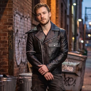 May include: A black leather jacket featuring a wide notched collar, a diagonal silver zipper closure, a flap pocket on the chest, and an additional zippered pocket on the sleeve. The jacket has structured shoulders and a fitted silhouette.