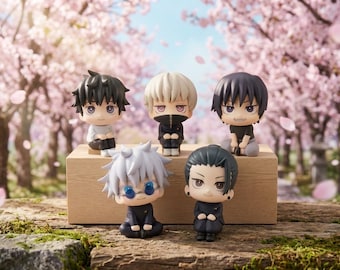 Puede incluir: Cinco figuras de anime estilo chibi dispuestas sobre un bloque de madera. Las figuras presentan peinados y atuendos distintos, incluyendo una con cabello blanco y gafas azules, una con cabello negro y otra con cabello rubio, todas sentadas.