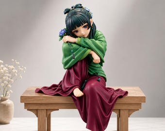 Puede incluir: Una figura de un personaje con cabello oscuro recogido en un moño, vistiendo una blusa verde de manga larga y una falda larga color granate. El personaje está sentado en un banco de madera, sosteniendo una pequeña flor azul cerca del rostro.