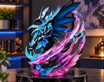 Puede incluir: Una figura de criatura similar a un dragón negro con alas grandes, rodeada de efectos de llamas azules y rosas translúcidas. La figura se asienta sobre una base circular con patrón de mármol negro, con detalles nítidos y una pose dinámica.