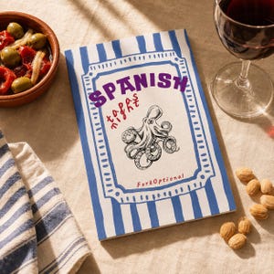May include: A rectangular book with a white cover featuring blue vertical stripes, a central frame, and a black ink illustration of an octopus. The text reads "SPANISH", "tapas", "night", and "ForkOptional" in purple and red ink.