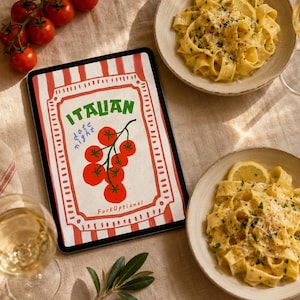 Peut inclure: Une tablette numérique affichant un graphique à rayures rouges et blanches, une grappe de tomates rouges et le texte "ITALIAN date night" et "ForkOptional". La tablette est entourée de deux bols de pâtes, de verres à vin et de tomates.