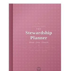 May include: A dusty rose planner with a grid pattern on the cover. The text reads: A LIFE WELL TENDED THE Stewardship Planner Bloom Grow Flourish FITNESS TRACES SPIRIT NUTRITION MANIFEST BOOKS FAITH PURPOSE GROWTH and a small circle with text.