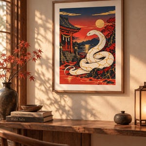Könnte beinhalten: Ein gerahmter Kunstdruck mit einer großen weißen Schlange mit goldenen Markierungen, die sich auf einem dunklen Felsen windet. Der Hintergrund zeigt einen roten Sonnenuntergang, einen traditionellen japanischen Tempel und rotblättrige Bäume. Text KanameRelic.