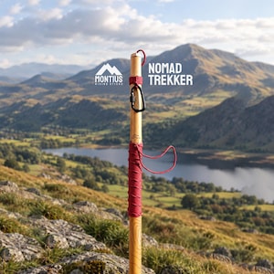 以下が含まれることがあります： 「Nomad Trekker」および「Montius Hiking Sticks」と記された木製のハイキングスティック。明るい茶色の木目調仕上げで、上部にはダークレッドのコードが巻き付けられ、同色の赤いリストループと黒い金属製のカラビナが取り付けられています。