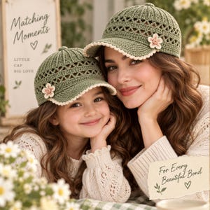 May include: Two olive green crochet baseball caps featuring an intricate openwork pattern, a scalloped cream-colored brim edge, and a small cream and pink crocheted flower accent on the side. The caps are designed with a structured crown.