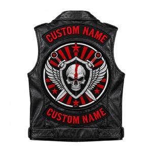 May include: A black leather waistcoat featuring a large circular embroidered patch on the back. The patch displays a skull with a red stripe, two crossed swords, wings, and red stars. The text CUSTOM NAME appears in red on top and bottom rockers.