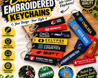 May include: A collection of rectangular embroidered keychains in various colors including black, red, yellow, orange, and blue. Each keychain features a metal ring and custom text or logos such as Zona Print, Redwire, D&D Enterprises, Agista Water, and Chelsea.