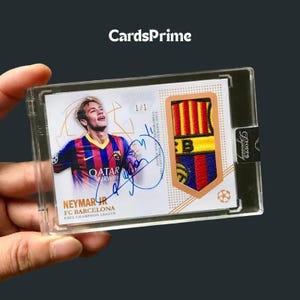 Op de afbeelding: Een Topps Dynasty 1/1 ruilkaart met Neymar Jr. in een FC Barcelona shirt, een handtekening in blauwe inkt en een ingebed FC Barcelona teamembleem. De kaart zit in een doorzichtige plastic beschermhouder met de tekst CardsPrime.