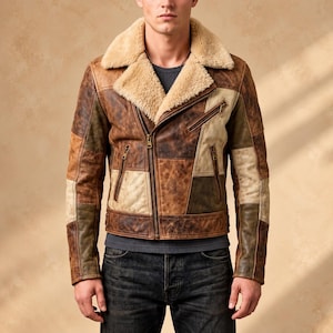 Könnte beinhalten: Eine Patchwork-Lederjacke mit beigem Lammfellkragen, asymmetrischem Frontreißverschluss und mehreren Reißverschlusstaschen. Die Jacke besteht aus verschiedenen braunen und beigen Lederteilen und wird über einem dunkelgrauen Shirt getragen.
