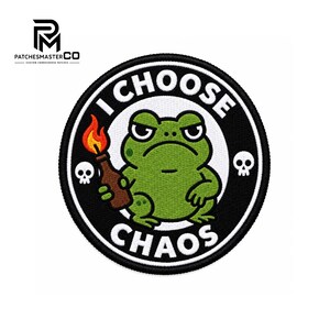 Puede incluir: Un parche bordado circular que muestra una rana verde con expresión gruñona sosteniendo una botella marrón con una llama naranja brillante. El texto I CHOOSE CHAOS está bordado en blanco sobre un borde negro, flanqueado por dos calaveras blancas.