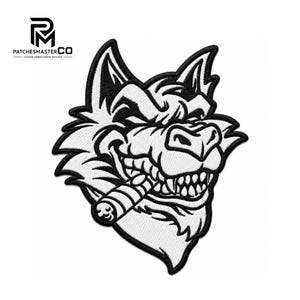 Puede incluir: Un parche bordado que presenta un gráfico en blanco y negro de una cabeza de lobo con una expresión sonriente, dientes afilados y un cigarro en la boca. El diseño está delineado con hilo negro grueso con relleno blanco y un borde negro.