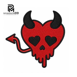 May include: An embroidered patch featuring a red heart-shaped skull with black devil horns, black heart-shaped eyes, and a small black nose. The design includes a red devil tail with a pointed tip and a dripping effect at the bottom edge.