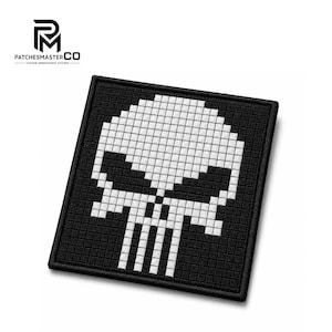 May include: A square embroidered patch featuring a pixelated white skull design on a black background. The skull has large, dark, angular eye sockets and a vertical nose cavity, all rendered in a grid-like pattern with a thick black border.