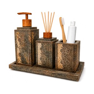 Puede incluir: Un juego de accesorios de baño que incluye un dispensador de jabón rectangular con bomba de madera, un difusor de varillas con palitos de madera y un porta cepillos de dientes. Cada pieza es de piedra marrón con flores talladas sobre una bandeja.