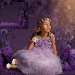 May include: A young girl wearing a lavender dress with a white lace overlay sits on a purple velvet couch. The couch has two pillows and is decorated with a floral pattern. The background is a purple and white floral backdrop. The text "Jessica Vallia Photography" is visible in the lower right corner of the image.