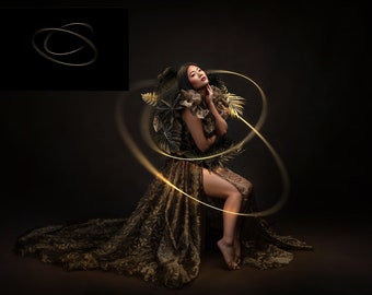 May include: A woman wearing a gold and brown dress with a leafy design, standing in front of a dark background with glowing gold circles around her.