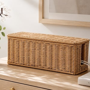Peut inclure: Une boîte de rangement pour câbles rectangulaire en osier tressé brun clair avec un couvercle amovible. La boîte présente un motif de tissage horizontal et une ouverture latérale pour faire passer les câbles électriques.