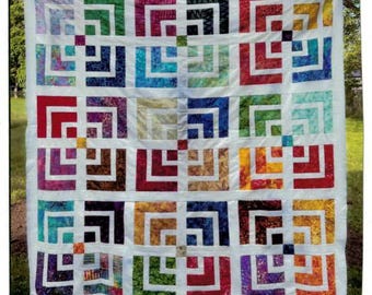 May include: A quilt featuring a grid of twelve square blocks, each composed of concentric L-shaped segments in various colors including red, blue, green, yellow, and purple, separated by white sashing and a white border frame.