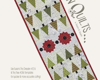 May include: A rectangular table runner pattern titled Tiny Tree Runner measuring 12 1/2 inches by 50 inches. The design features rows of green triangular trees on a white background with script and polka dot patterns, accented by two red flowers.