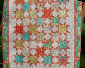 May include: A patchwork quilt featuring a repeating star pattern in shades of coral, teal, yellow, and white. The design includes square blocks with floral and gingham prints, surrounded by a wide border with a teal and coral floral pattern.