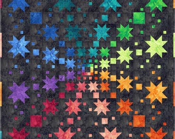 May include: A square quilt featuring a dark charcoal gray background with a vibrant rainbow gradient pattern. The design consists of multi-sized eight-pointed stars and small squares arranged in a swirling spectrum of blue, purple, red, orange, yellow, and green.