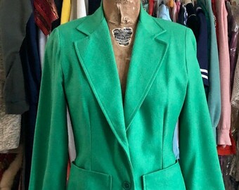May include: A bright green blazer with a single button closure and two patch pockets. The blazer has a notched collar and long sleeves.