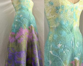 May include: A sleeveless, light green, yellow, and purple dress with a floral print. The dress has a fitted bodice and a flowing skirt.