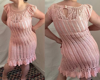 Puede incluir: Un vestido de crochet rosa con un dobladillo festoneado y una espalda con abertura de ojo de cerradura. El vestido está hecho con un delicado patrón de punto abierto.