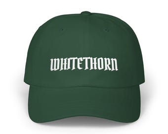 May include: A dark forest green baseball cap featuring the word WHITETHORN embroidered in white capital letters across the front panel. The cap has a structured crown, a curved brim, and a button at the top center of the dome.