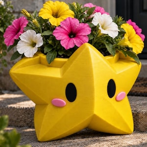 May include: A bright yellow star-shaped planter featuring two black oval eyes and two small pink oval cheeks. The planter is filled with a vibrant arrangement of petunia flowers in shades of yellow, white, and magenta with green foliage.