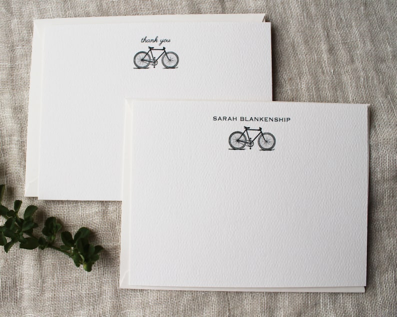 May include: Two white blank note cards with a black bicycle illustration. The top card says "thank you" and the bottom card says "SARAH BLANKENSHIP".
