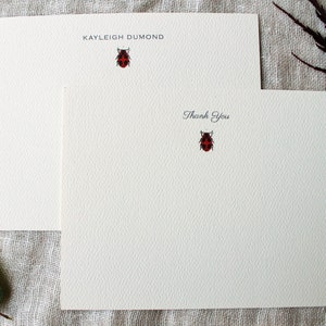 Pu&ograve; includere: Due biglietti da visita bianchi con un'illustrazione di coccinella e il testo "KAYLEIGH DUMOND" sul biglietto superiore e "Grazie" sul biglietto inferiore.